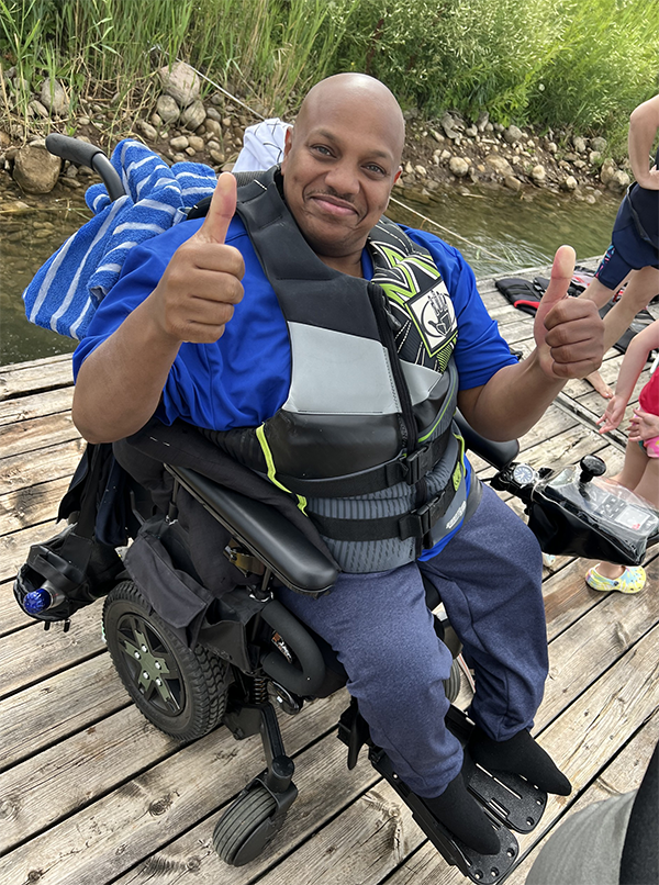 SCIO community member in his wheelchair, suited up on the dock ready to try adaptive waterskiing