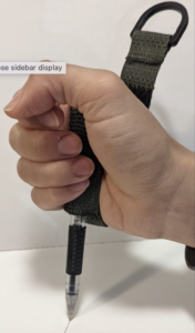 Cuff in hand to help person sign name with pen