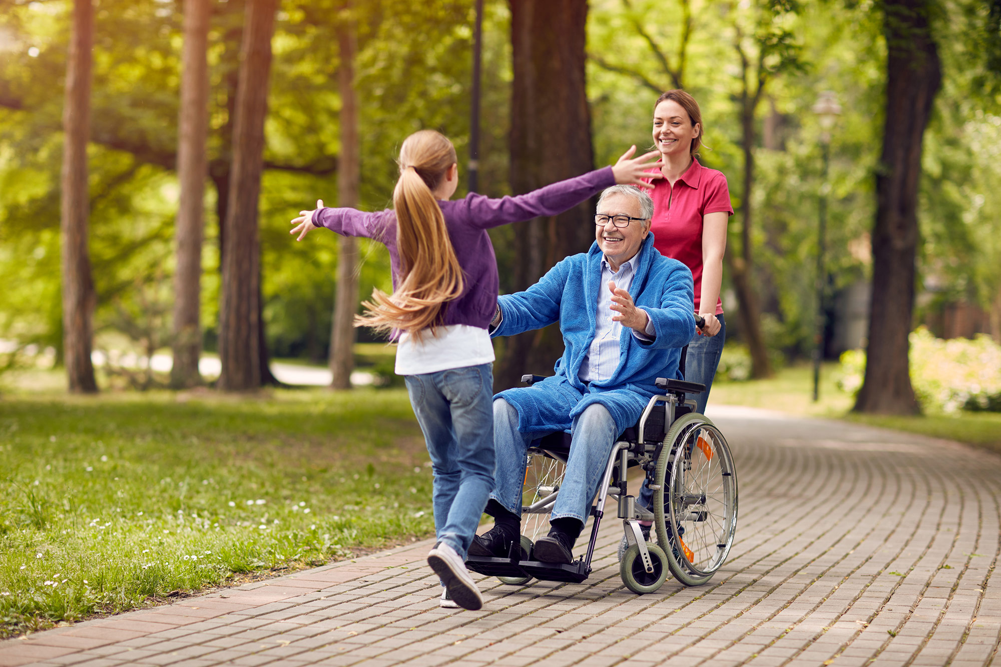 Cheerful disabled grandfather in wheelchair welcoming his granddaughter stock photo