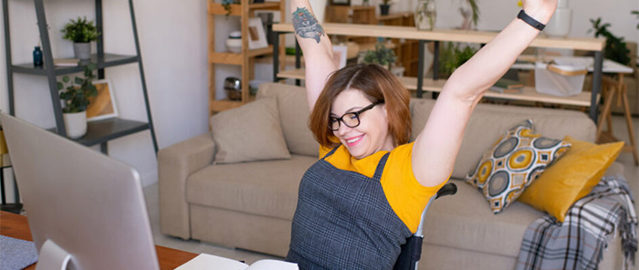 lady cheering at computer in wheelchair