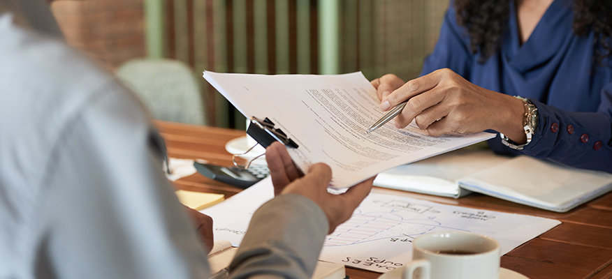 Two lawyers consulting over paperwork.