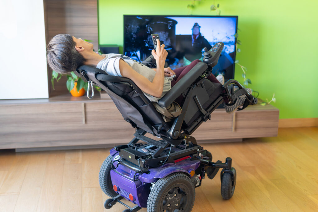 Woman watching tv in a tilting power seating wheelchair