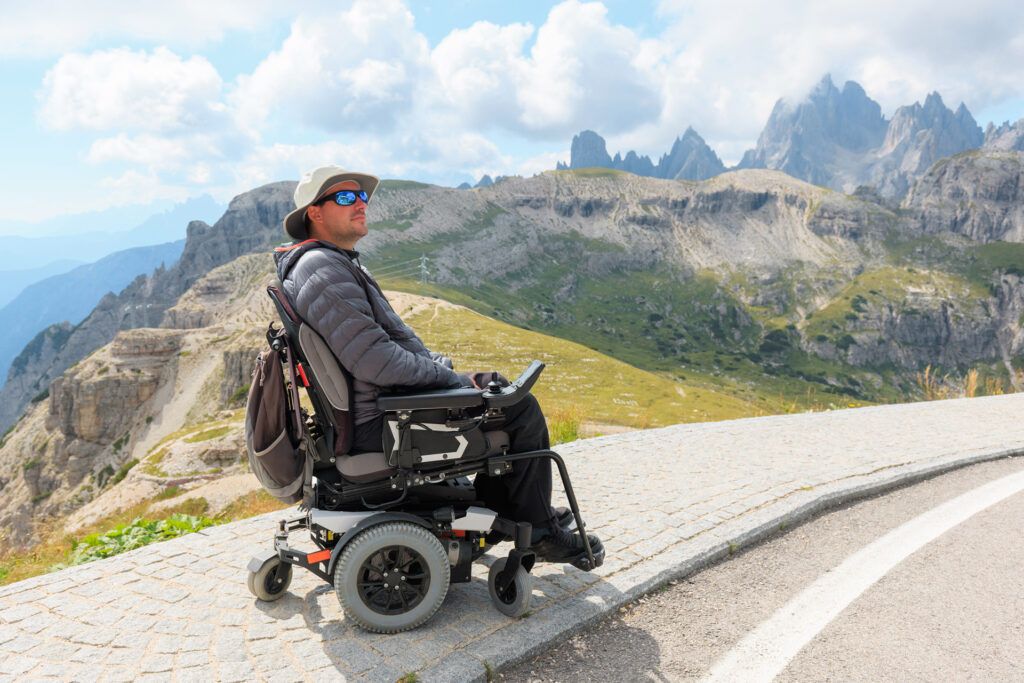 A man in mountainous surroundings using a power wheelchair