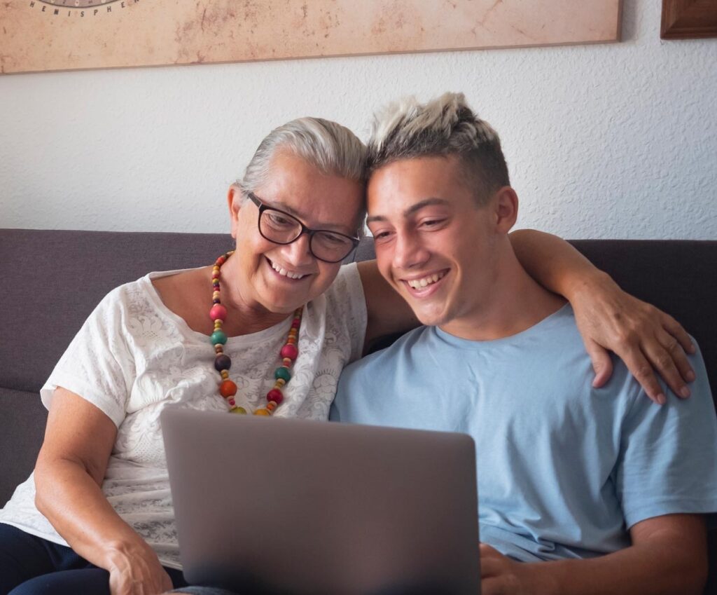 Women with teenage boy looking at laptop
