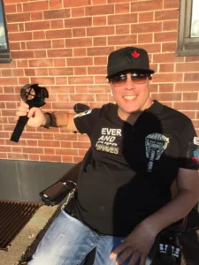 Man in power wheelchair with hat and sunglasses holding cup holder